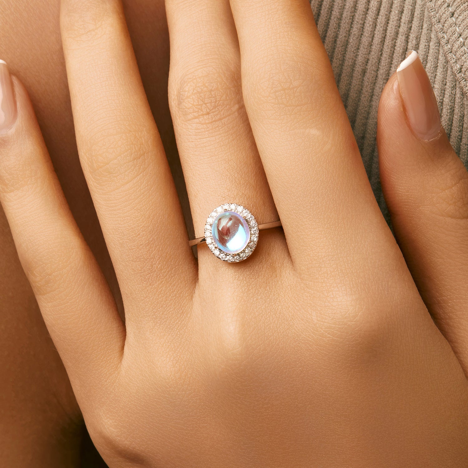 Stackable sterling silver moonstone ring on finger, Ins style moonstone ring with celestial glow, Recycled silver moonstone stacking band jewelry,Close-up of natural moonstone in silver ring setting, Minimalist moonstone ring for layered arm candy