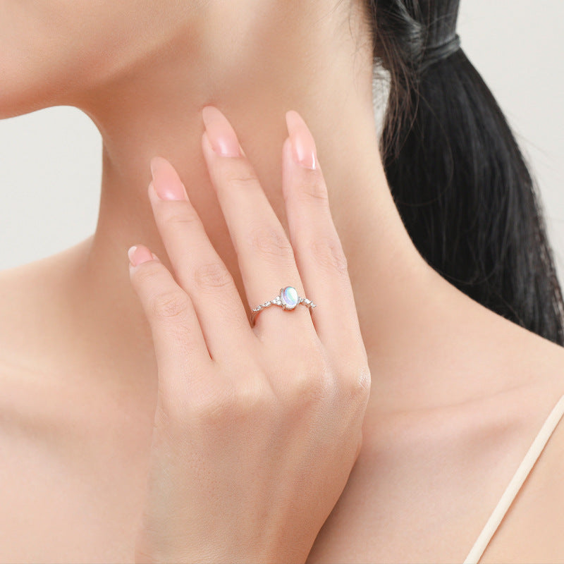 Stackable sterling silver moonstone ring on finger, Ins style moonstone ring with celestial glow, Recycled silver moonstone stacking band jewelry,Close-up of natural moonstone in silver ring setting, Minimalist moonstone ring for layered arm candy