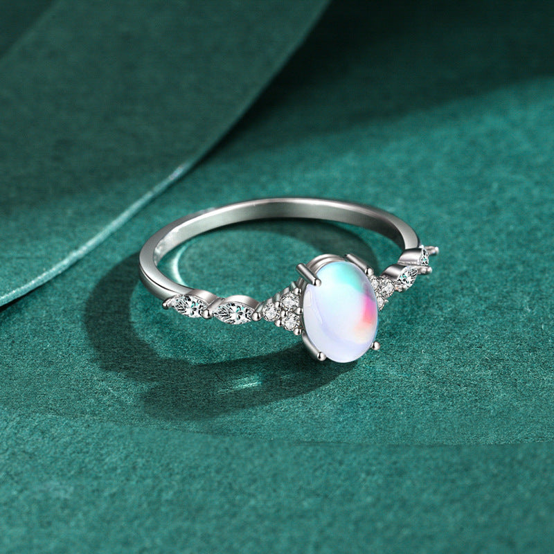 Stackable sterling silver moonstone ring on finger, Ins style moonstone ring with celestial glow, Recycled silver moonstone stacking band jewelry,Close-up of natural moonstone in silver ring setting, Minimalist moonstone ring for layered arm candy