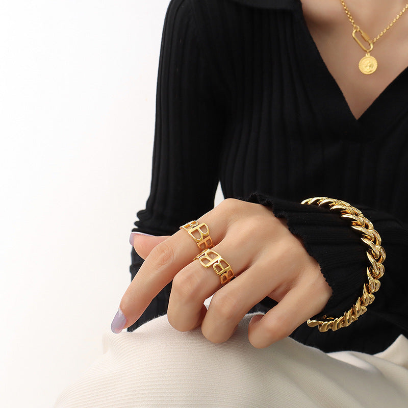 Titanium steel 18K gold plated geometric stripe ring on hand, Close-up of horizontal striped design on gold plated ring, Luxury gift box with 18K gold titanium steel jewelry, Water-resistant gold plated ring with recycled titanium steel,Two-year guarantee hypoallergenic gold tone ring