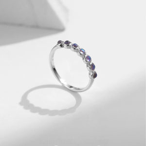 Stackable sterling silver moonstone ring on finger, Ins style moonstone ring with celestial glow, Recycled silver moonstone stacking band jewelry,Close-up of natural moonstone in silver ring setting, Minimalist moonstone ring for layered arm candy