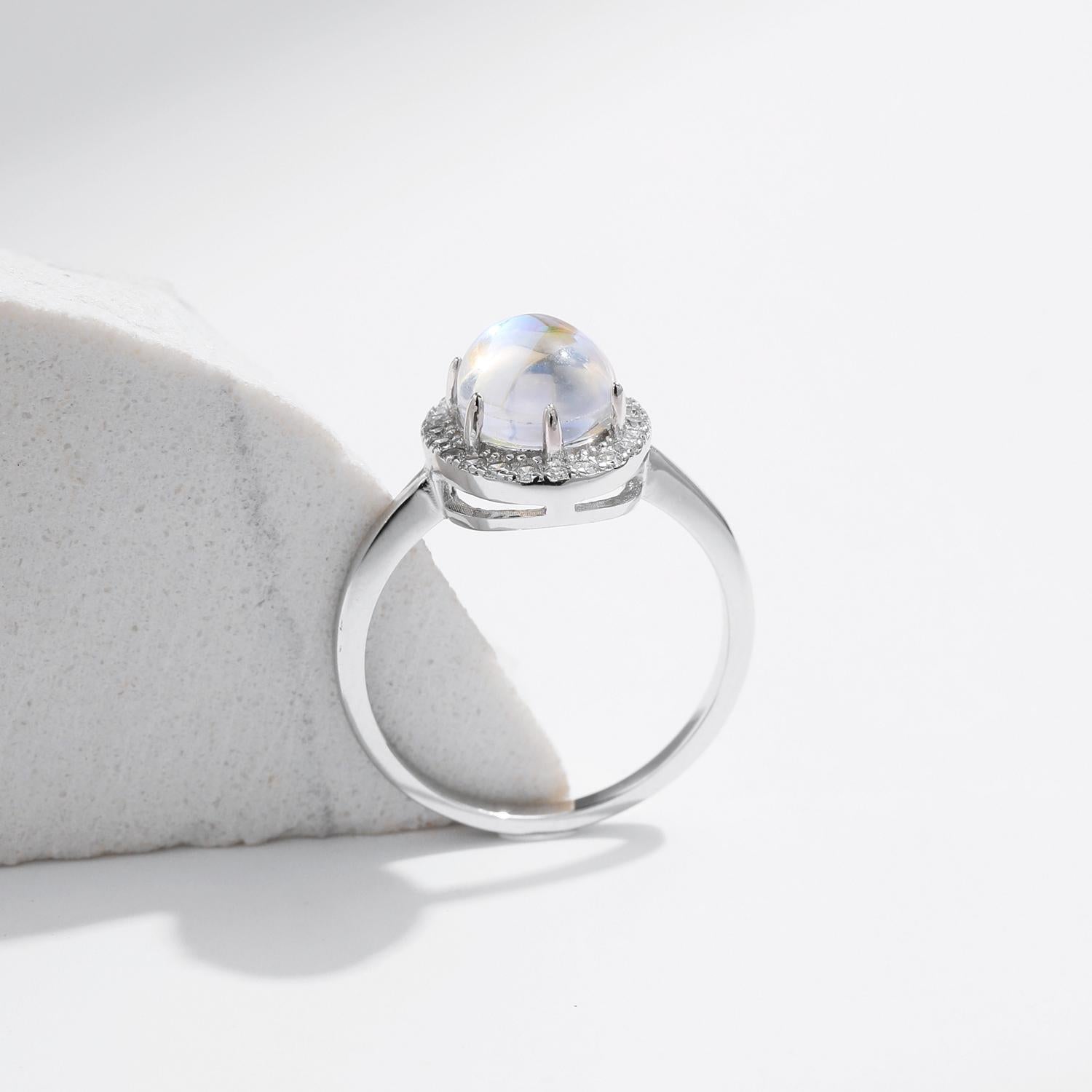 Stackable sterling silver moonstone ring on finger, Ins style moonstone ring with celestial glow, Recycled silver moonstone stacking band jewelry,Close-up of natural moonstone in silver ring setting, Minimalist moonstone ring for layered arm candy