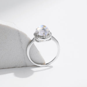 Stackable sterling silver moonstone ring on finger, Ins style moonstone ring with celestial glow, Recycled silver moonstone stacking band jewelry,Close-up of natural moonstone in silver ring setting, Minimalist moonstone ring for layered arm candy