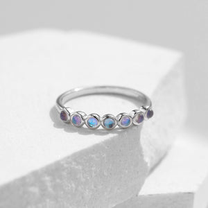 Stackable sterling silver moonstone ring on finger, Ins style moonstone ring with celestial glow, Recycled silver moonstone stacking band jewelry,Close-up of natural moonstone in silver ring setting, Minimalist moonstone ring for layered arm candy