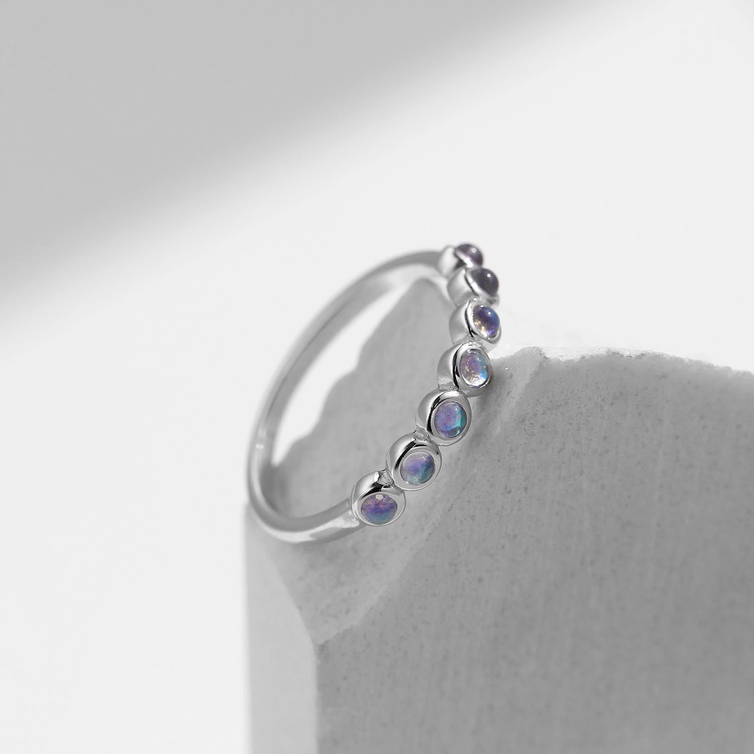 Stackable sterling silver moonstone ring on finger, Ins style moonstone ring with celestial glow, Recycled silver moonstone stacking band jewelry,Close-up of natural moonstone in silver ring setting, Minimalist moonstone ring for layered arm candy