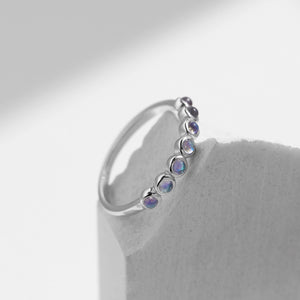 Stackable sterling silver moonstone ring on finger, Ins style moonstone ring with celestial glow, Recycled silver moonstone stacking band jewelry,Close-up of natural moonstone in silver ring setting, Minimalist moonstone ring for layered arm candy