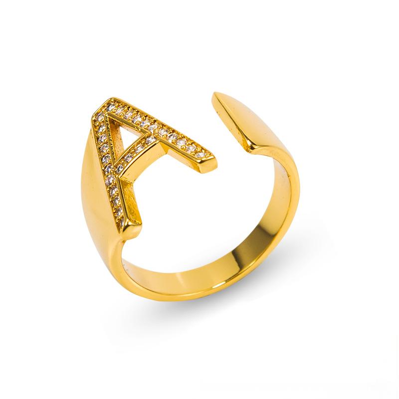 Adjustable brass letter A ring with micro-paved zirconia stones close-up, Top view of 18K gold-plated brass alphabet ring set spread on velvet, Side view of brass letter D ring worn on finger with adjustable opening, Macro shot of zirconia stone details and brass texture on alphabet ring, 