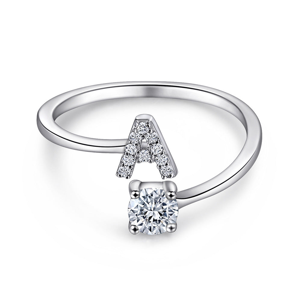 Close-up of S925 sterling silver rhodium-plated adjustable letter A ring with zirconia center stone, Top view of 26 alphabet sterling silver rings spread display with adjustable clasp detail, Side-lit shot of rhodium-plated letter S ring worn on finger with sparkling zirconia, Macro view of zirconia stone brilliance and rhodium-plated silver surface texture