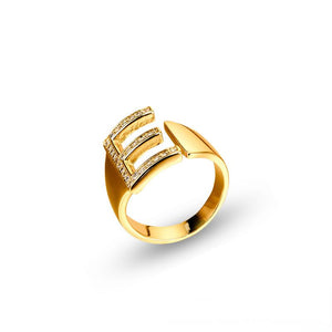 Adjustable brass letter A ring with micro-paved zirconia stones close-up, Top view of 18K gold-plated brass alphabet ring set spread on velvet, Side view of brass letter D ring worn on finger with adjustable opening, Macro shot of zirconia stone details and brass texture on alphabet ring, 