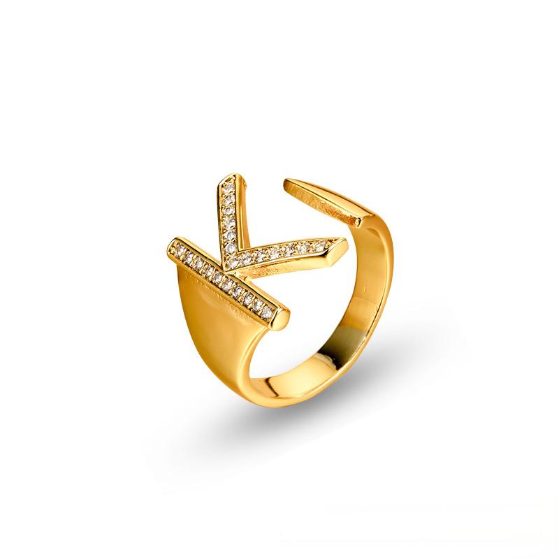 Adjustable brass letter A ring with micro-paved zirconia stones close-up, Top view of 18K gold-plated brass alphabet ring set spread on velvet, Side view of brass letter D ring worn on finger with adjustable opening, Macro shot of zirconia stone details and brass texture on alphabet ring, 