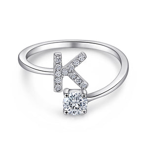 Close-up of S925 sterling silver rhodium-plated adjustable letter A ring with zirconia center stone, Top view of 26 alphabet sterling silver rings spread display with adjustable clasp detail, Side-lit shot of rhodium-plated letter S ring worn on finger with sparkling zirconia, Macro view of zirconia stone brilliance and rhodium-plated silver surface texture