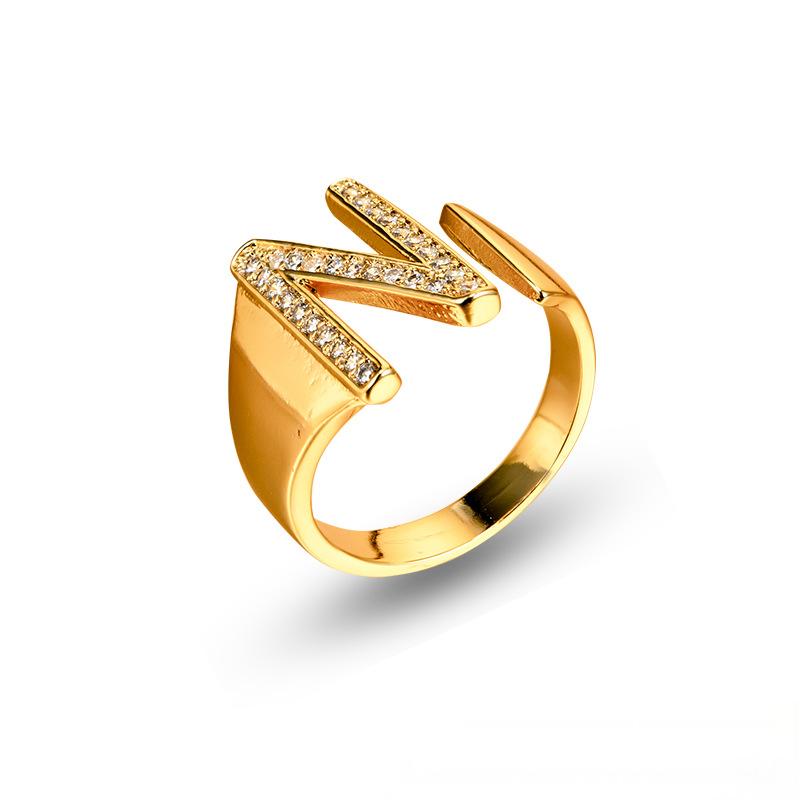 Adjustable brass letter A ring with micro-paved zirconia stones close-up, Top view of 18K gold-plated brass alphabet ring set spread on velvet, Side view of brass letter D ring worn on finger with adjustable opening, Macro shot of zirconia stone details and brass texture on alphabet ring, 