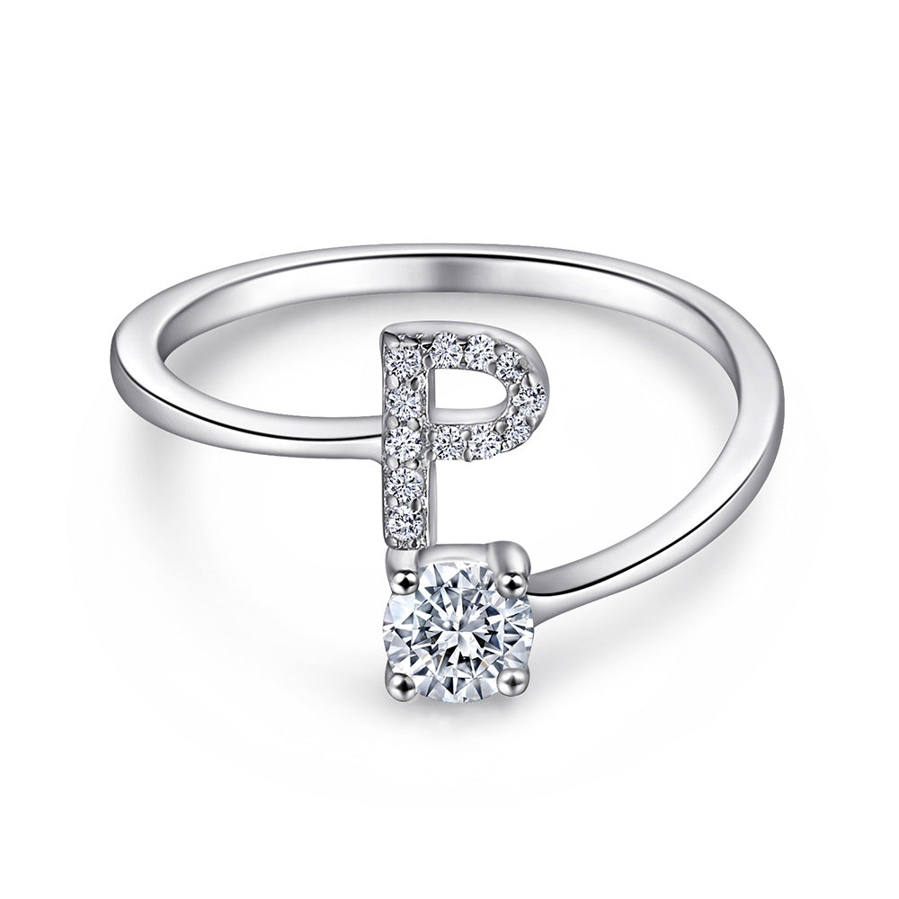 Close-up of S925 sterling silver rhodium-plated adjustable letter A ring with zirconia center stone, Top view of 26 alphabet sterling silver rings spread display with adjustable clasp detail, Side-lit shot of rhodium-plated letter S ring worn on finger with sparkling zirconia, Macro view of zirconia stone brilliance and rhodium-plated silver surface texture