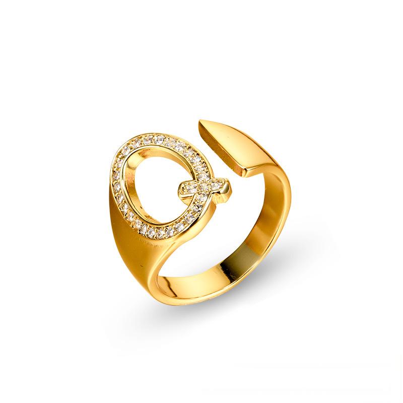 Adjustable brass letter A ring with micro-paved zirconia stones close-up, Top view of 18K gold-plated brass alphabet ring set spread on velvet, Side view of brass letter D ring worn on finger with adjustable opening, Macro shot of zirconia stone details and brass texture on alphabet ring, 