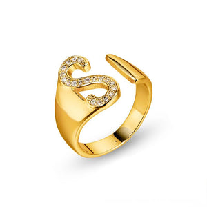 Adjustable brass letter A ring with micro-paved zirconia stones close-up, Top view of 18K gold-plated brass alphabet ring set spread on velvet, Side view of brass letter D ring worn on finger with adjustable opening, Macro shot of zirconia stone details and brass texture on alphabet ring, 