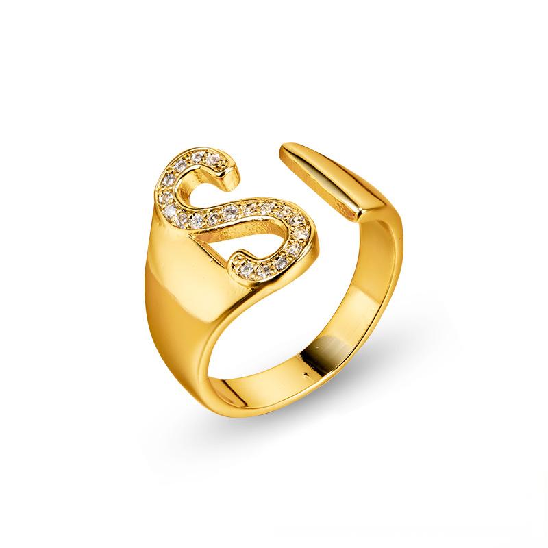 Adjustable brass letter A ring with micro-paved zirconia stones close-up, Top view of 18K gold-plated brass alphabet ring set spread on velvet, Side view of brass letter D ring worn on finger with adjustable opening, Macro shot of zirconia stone details and brass texture on alphabet ring, 