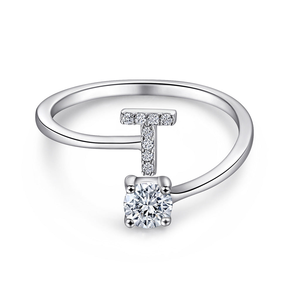 Close-up of S925 sterling silver rhodium-plated adjustable letter A ring with zirconia center stone, Top view of 26 alphabet sterling silver rings spread display with adjustable clasp detail, Side-lit shot of rhodium-plated letter S ring worn on finger with sparkling zirconia, Macro view of zirconia stone brilliance and rhodium-plated silver surface texture