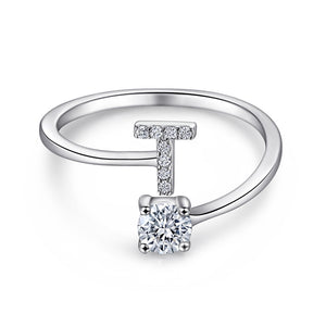 Close-up of S925 sterling silver rhodium-plated adjustable letter A ring with zirconia center stone, Top view of 26 alphabet sterling silver rings spread display with adjustable clasp detail, Side-lit shot of rhodium-plated letter S ring worn on finger with sparkling zirconia, Macro view of zirconia stone brilliance and rhodium-plated silver surface texture