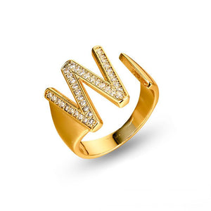 Adjustable brass letter A ring with micro-paved zirconia stones close-up, Top view of 18K gold-plated brass alphabet ring set spread on velvet, Side view of brass letter D ring worn on finger with adjustable opening, Macro shot of zirconia stone details and brass texture on alphabet ring, 