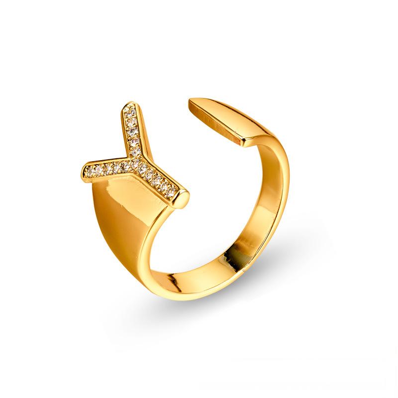 Adjustable brass letter A ring with micro-paved zirconia stones close-up, Top view of 18K gold-plated brass alphabet ring set spread on velvet, Side view of brass letter D ring worn on finger with adjustable opening, Macro shot of zirconia stone details and brass texture on alphabet ring, 