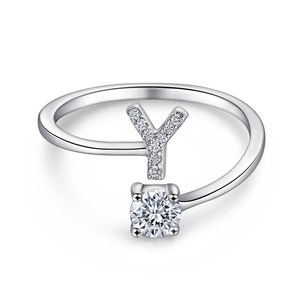 Close-up of S925 sterling silver rhodium-plated adjustable letter A ring with zirconia center stone, Top view of 26 alphabet sterling silver rings spread display with adjustable clasp detail, Side-lit shot of rhodium-plated letter S ring worn on finger with sparkling zirconia, Macro view of zirconia stone brilliance and rhodium-plated silver surface texture