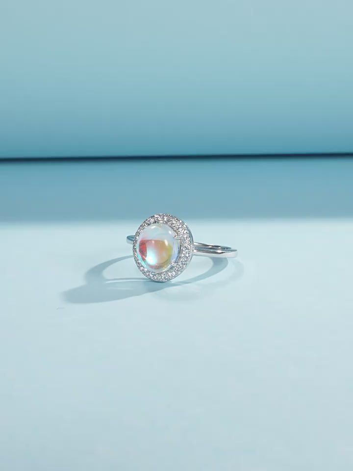 Stackable sterling silver moonstone ring on finger, Ins style moonstone ring with celestial glow, Recycled silver moonstone stacking band jewelry,Close-up of natural moonstone in silver ring setting, Minimalist moonstone ring for layered arm candy