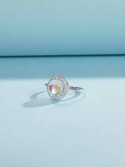 Stackable sterling silver moonstone ring on finger, Ins style moonstone ring with celestial glow, Recycled silver moonstone stacking band jewelry,Close-up of natural moonstone in silver ring setting, Minimalist moonstone ring for layered arm candy