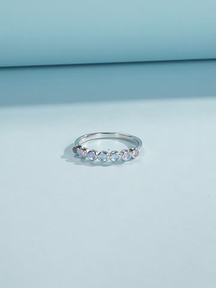 Stackable sterling silver moonstone ring on finger, Ins style moonstone ring with celestial glow, Recycled silver moonstone stacking band jewelry,Close-up of natural moonstone in silver ring setting, Minimalist moonstone ring for layered arm candy